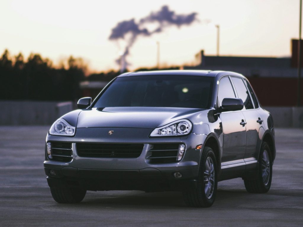 Porsche SUV parked with factory in background